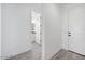 Inviting hallway view featuring a white front door and an open entry into a well lit bathroom at 18123 W Hiddenview Dr, Goodyear, AZ 85338
