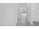 Hallway with tile flooring leading to living area with large windows and a door on the right at 18123 W Hiddenview Dr, Goodyear, AZ 85338