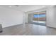 Open living space with gray wood flooring, sliding glass doors to the backyard at 18123 W Hiddenview Dr, Goodyear, AZ 85338