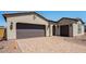 Exterior view of a home with a brick driveway and a two-car garage at 18150 W Tanglewood Dr, Goodyear, AZ 85338