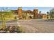Exterior view of the village center with manicured landscaping and a spacious parking area at 18150 W Tanglewood Dr, Goodyear, AZ 85338
