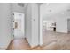Open-concept hallway with hardwood floors leading to a spacious living area and an adjacent bedroom at 18150 W Tanglewood Dr, Goodyear, AZ 85338