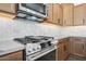 Close-up view of modern gas range and tile backsplash in kitchen at 18150 W Tanglewood Dr, Goodyear, AZ 85338