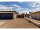 Wide driveway leading to a blue garage door with a view of the backyard gate and perimeter wall at 18309 N 39Th Ave, Glendale, AZ 85308