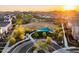 Stunning aerial view of community park featuring large open fields, shaded seating areas, and lush green landscaping at sunset at 1919 W Hide Trl, Phoenix, AZ 85085