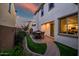 Cozy backyard patio area featuring an outdoor dining set, lush landscaping, and exterior view of the kitchen with modern appliances at 1919 W Hide Trl, Phoenix, AZ 85085
