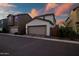 Charming two-story home with a tandem three-car garage showcasing an attractive brick-paved driveway and manicured landscaping at 1919 W Hide Trl, Phoenix, AZ 85085