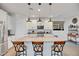 Spacious kitchen island with granite countertops, seating for three, and pendant lighting, perfect for casual dining at 1919 W Hide Trl, Phoenix, AZ 85085