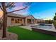 View of the backyard with a tiled pool and covered patio with an adjacent lush lawn and desert landscaping at 22296 E Maya Rd, Queen Creek, AZ 85142