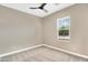 Bedroom features neutral walls, plush carpet, ceiling fan, and a large window with bright natural light at 22296 E Maya Rd, Queen Creek, AZ 85142