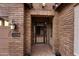 Inviting front entrance with brickwork, a security gate, and a well-lit porch, enhancing curb appeal and security at 22296 E Maya Rd, Queen Creek, AZ 85142