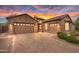 Beautiful brick home with a paver driveway and a well-manicured front yard at sunset at 22296 E Maya Rd, Queen Creek, AZ 85142