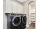 Well-equipped laundry room with high-end washer and dryer, with storage cabinets, and shelving in alcove at 22296 E Maya Rd, Queen Creek, AZ 85142