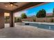Covered patio looking out to a backyard and pool with a waterfall and a small spa tub at 22296 E Maya Rd, Queen Creek, AZ 85142