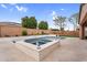 Outdoor pool and spa featuring travertine tile deck and fountain, surrounded by lush landscaping for privacy at 22296 E Maya Rd, Queen Creek, AZ 85142