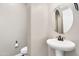 Stylish powder room with a pedestal sink, contemporary faucet, and convenient toilet placement at 22296 E Maya Rd, Queen Creek, AZ 85142