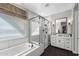 Bright bathroom featuring a glass-enclosed shower, soaking tub, and stylish vanity at 22302 E Russet Rd, Queen Creek, AZ 85142
