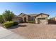 Charming single-story home with a three-car garage, stone accents, and a brick driveway at 22302 E Russet Rd, Queen Creek, AZ 85142