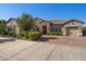 Charming single-story home with three-car garage, manicured landscaping, stone accents, and brick driveway at 22302 E Russet Rd, Queen Creek, AZ 85142