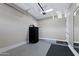 Spacious garage features a sleek black refrigerator and neutral-colored walls and flooring at 22302 E Russet Rd, Queen Creek, AZ 85142