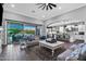 Bright and airy living room with dark wood floors, a ceiling fan, and an open floor plan flowing into the kitchen at 22302 E Russet Rd, Queen Creek, AZ 85142