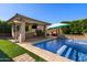 Stylish outdoor kitchen with a built-in grill and dining area next to a backyard pool at 22302 E Russet Rd, Queen Creek, AZ 85142