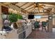Outdoor kitchen with granite countertops, stainless steel grill, and outdoor barstool seating at 22302 E Russet Rd, Queen Creek, AZ 85142