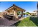 Covered outdoor kitchen with bar seating and views of the swimming pool and backyard at 22302 E Russet Rd, Queen Creek, AZ 85142