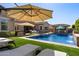 Stunning pool and backyard with lush turf, tanning ledge, and covered patio area at 22302 E Russet Rd, Queen Creek, AZ 85142