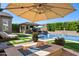 Backyard oasis with a pool, spa, fire pit, outdoor kitchen, and lush landscaping at 22302 E Russet Rd, Queen Creek, AZ 85142