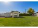 Spacious backyard with lush green grass, a shed, and mature trees, perfect for outdoor activities at 2236 W Shaw Butte Dr, Phoenix, AZ 85029