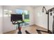 Bright home gym features modern exercise equipment, wood floors, and sliding glass doors that open to the backyard at 2236 W Shaw Butte Dr, Phoenix, AZ 85029