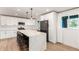 Bright kitchen with white cabinets, stainless appliances, and a large quartz island with bar stool seating at 2236 W Shaw Butte Dr, Phoenix, AZ 85029