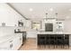 Spacious kitchen with white cabinets, stainless appliances, a center island with barstool seating, and modern lighting at 2236 W Shaw Butte Dr, Phoenix, AZ 85029