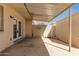 Back patio with covered awning, access to the house, and a white brick privacy wall at 225 N Standage -- # 30, Mesa, AZ 85201