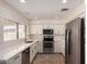 Updated kitchen with stainless steel appliances, white cabinets, and a tiled floor, creating a clean, modern look at 234 S Neely St, Gilbert, AZ 85233