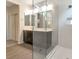 Bathroom featuring double sinks and glass enclosed shower with white tiled walls and grey tile flooring at 2491 N 149Th Ln, Goodyear, AZ 85395