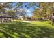 Community park with green grass, mature trees, a basketball court, and a covered picnic area at 2491 N 149Th Ln, Goodyear, AZ 85395