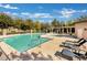 Community pool featuring a pergola, lounge chairs, and mature trees in a fenced area at 2491 N 149Th Ln, Goodyear, AZ 85395
