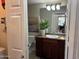 Bathroom features a cherry wood vanity, a toilet, and decorative plants and art at 29606 N Tatum Blvd # 276, Cave Creek, AZ 85331