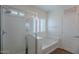Well lit bathroom featuring a tiled shower, bathtub, and bright windows at 2969 E Trigger Way, Gilbert, AZ 85297
