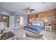 Primary bedroom with a wooden accent wall, a large bed, seating and ensuite bathroom at 2969 E Trigger Way, Gilbert, AZ 85297