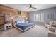 A cozy bedroom features a wooden accent wall, a large bed and comfortable seating at 2969 E Trigger Way, Gilbert, AZ 85297