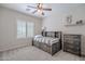 Charming bedroom featuring plantation shutters, ceiling fan, carpet flooring, and wood furniture at 2969 E Trigger Way, Gilbert, AZ 85297