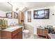 Cozy bathroom with cherry-stained vanity, granite countertop, updated fixtures and TV at 29972 N Bryce Trl, San Tan Valley, AZ 85144