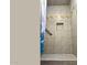 Shower stall with tiled walls, a grab bar, and decorative tile accent at 29972 N Bryce Trl, San Tan Valley, AZ 85144