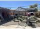 Spacious backyard with a custom checkered design of artificial grass and concrete and shaded seating area at 3020 N 64Th Dr, Phoenix, AZ 85033