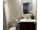 A charming bathroom with a white sink vanity, decorative accents, and a standard toilet at 3020 N 64Th Dr, Phoenix, AZ 85033