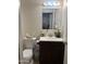 A charming bathroom with a white sink vanity, decorative accents, and a standard toilet at 3020 N 64Th Dr, Phoenix, AZ 85033