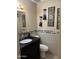 A cozy bathroom featuring a black vanity with a unique design and decorative tile accents at 3020 N 64Th Dr, Phoenix, AZ 85033